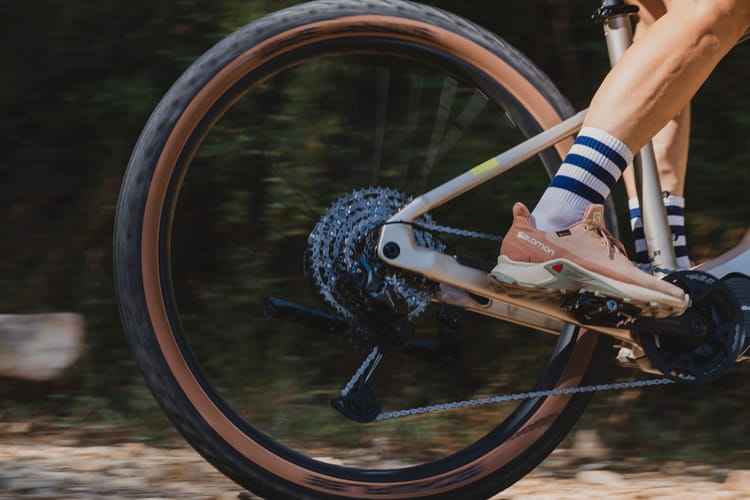 A groupset for a bike riding down a fast descent with the wheel blurred out. 